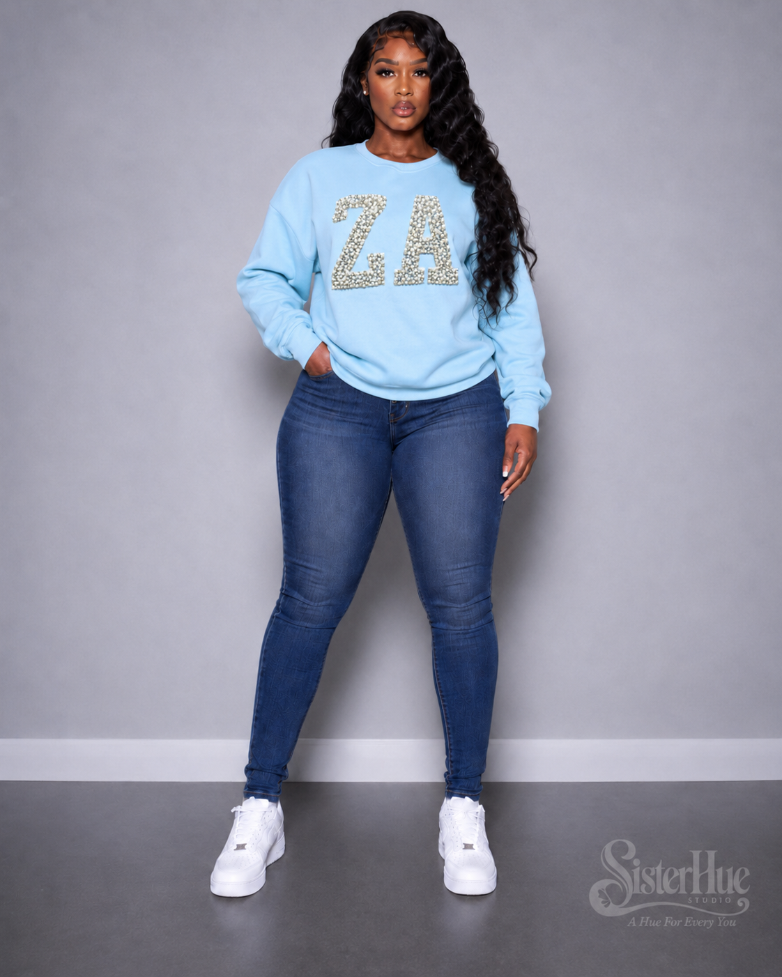 Model wearing the powder-blue Pearl Crewneck with hand-set pearl lettering across the chest